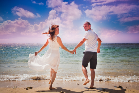 honeymoon couple walking at beachの写真素材