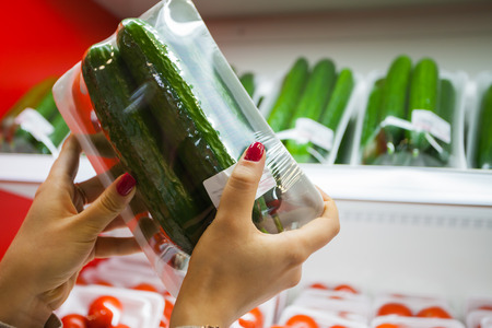 Image of packaged cucumber with woman hand in the supermarketの写真素材