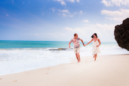 wedding couple jogging or running on the beachの写真素材