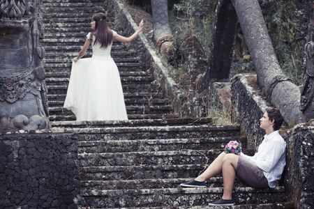 Retro photo of unusual couple on the stairs near mystical hotelの写真素材