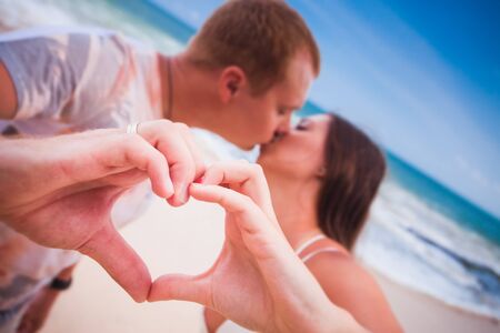 young couple with love sign by handsの写真素材