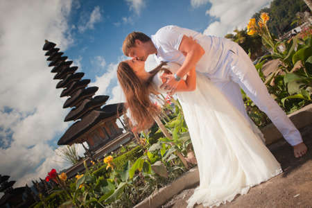 wedding couple near the famous temple at beratan lake, Baliの写真素材
