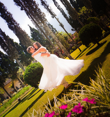 Happy couple at Bali park, bride wears a white wedding dressの写真素材