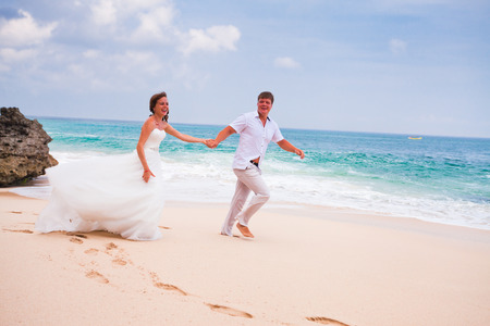 happy couple running at the beachの写真素材