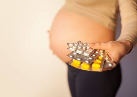 Pregnant woman uses vitamin tablets for healthy nutritionの写真素材