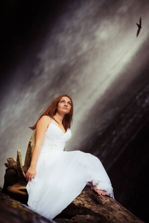 young woman traveling near the waterfall, Indonesiaの写真素材