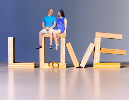 Lovers at abstract background with golden rings for proposingの写真素材