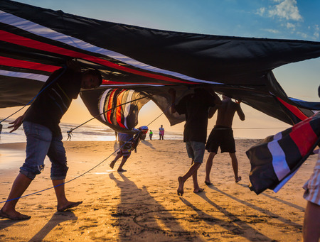 INDONESIA - AUGUST 17: Indonesian boys going to fly a kite near the coast on the background of clear sky  AUGUST 17, 2014. INDONESIA. During the Indonesian holidays, there are competitions of flying kite, this is a national traditionsのeditorial素材