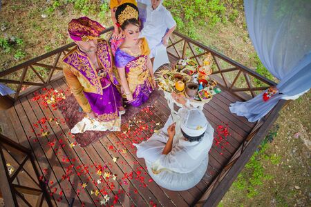 balinese wedding ceremony with sitting in the gazebo newlywedsの写真素材