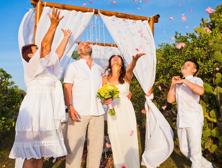 wedding ceremony of mature couple and their family dressed in whiteの写真素材