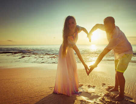 Photo of young couple with love sign by hands, yellow filter processingの写真素材