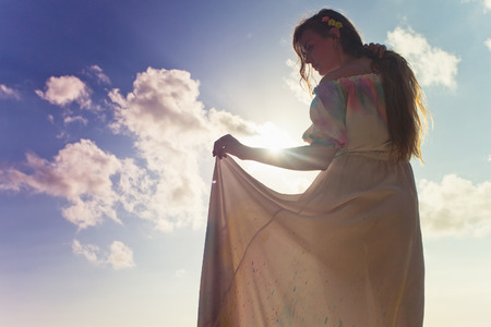 beautiful bride dressed in wedding dress, at blue sky backgroundの写真素材