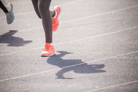 marathon of womens feet jogging outdoor by the road with copy space for text