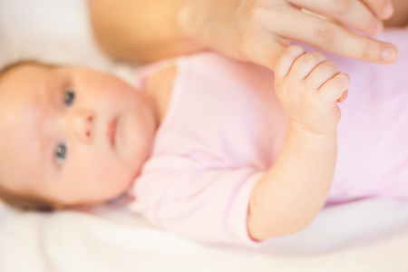Baby holding mother finger, there is concept or idea of care, family and happiness at the home, like mother caring for newbornの写真素材