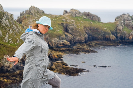 Picture of a girl, resisting strong winds at the edge of the world - Finister in France.