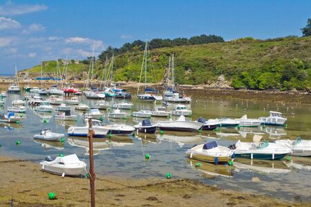 Picture of boats, standing at low tide on the coast of the island Belle Ile en Mer. France.のeditorial素材