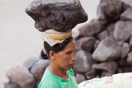 BALI, INDONESIA - SEP 23: hard work of woman, she is a stone on the head, INDONESIA 23 September 2012のeditorial素材