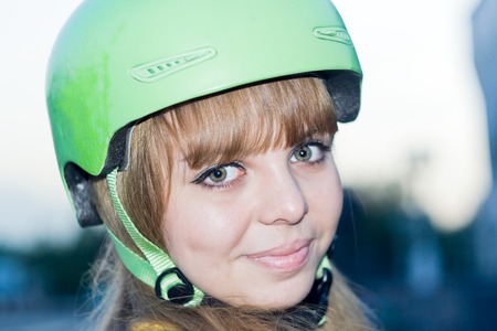 Sport (Cyclist, snowboarder) young beautiful women teenager in green helmet. She is smiling and looking at the camera.の写真素材