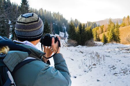 Caucasian young man (tourist) looking through the camera and taking pictureの写真素材