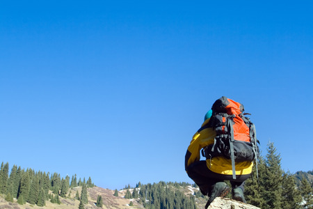 Climbing young adult at the top of summit with aerial view of blue sky and mountainの写真素材