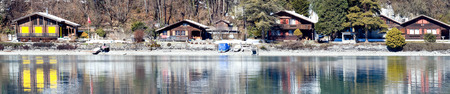 Horizontal panorama of the hotels on the lake. In the foreground a beautiful reflection of the hotels with an emerald hue, Interlaken, Switzerlandのeditorial素材