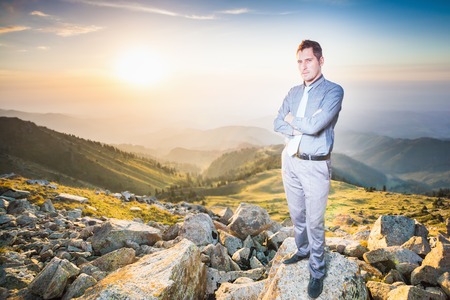 Image of successful businessman at top of mountain looking at camera. Concept of professional career and future plans in business.の写真素材