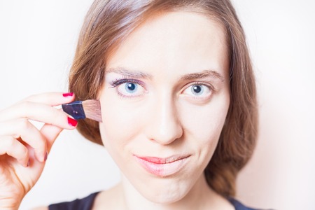 Young woman before and after natural makeup. Concept of facial make-up - eyes, eyebrows, eyelashes, lipsの写真素材
