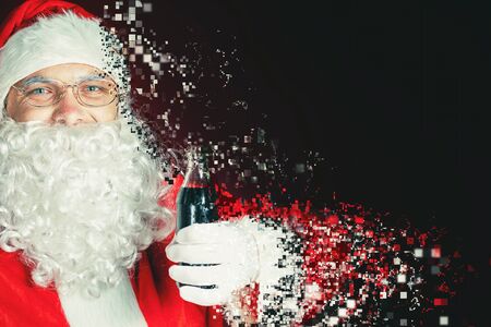 Santa Claus holding Cola fresh beverage at glass bottle. Christmas holiday, New Year. Photoshop, art effect of pixelated decomposition. Copy space for disign, text at red backgroundの写真素材