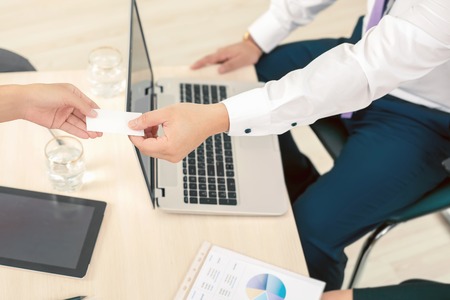 successful deal, businessman gives businesswoman a business card or visit card with a white...