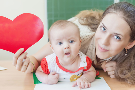 Teacher near blackboard teaching child, baby.の写真素材