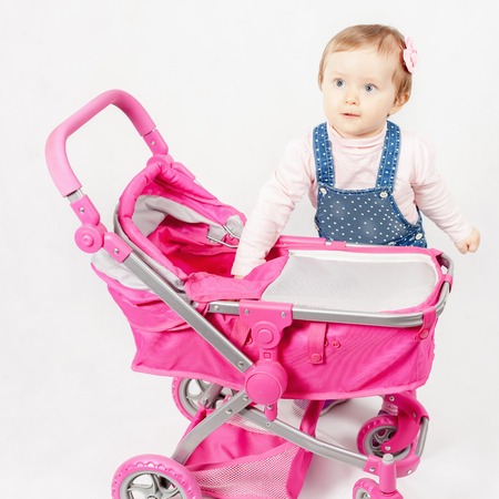 Cute little girl playing with baby stroller. Baby carriage. Children's World shopの写真素材