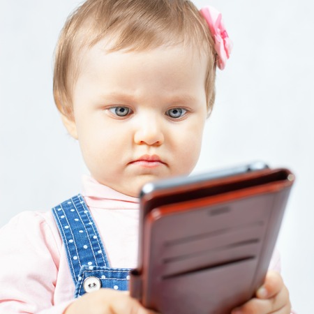 Image of funny baby make selfie photo on mobile phone. Newborn looking at the camera surprised! Baby lifeの写真素材