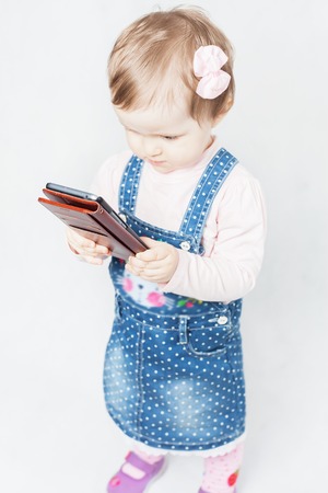 Baby holding a mobile phone, use the internet or watching cartoonsの写真素材