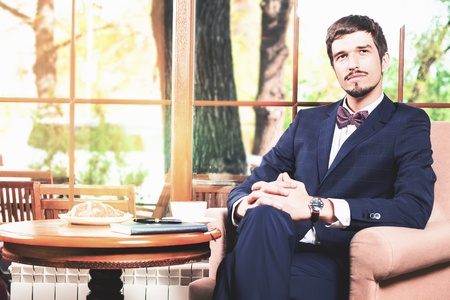 Handsome male has a french breakfast at cafe restaurant. Smiling businessman. Elegant successful man. Mustacheの写真素材