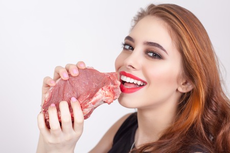 Image of woman holding raw meat at the white background. Healthy eating. Meat recipes, expiration date, shelf lifeの写真素材