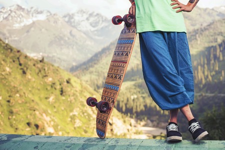 Portrait of cool, funny handsome man with skateboard outdoor at mountain. Skatebord at mauntain. Real guy with strong character and personality. Hipyの写真素材