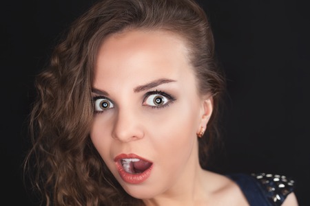 Young surprised pretty girl with magnetic eyes looking at camera. Emotion, fear, delight. Party time! Fashion, Glamour Ladyの写真素材