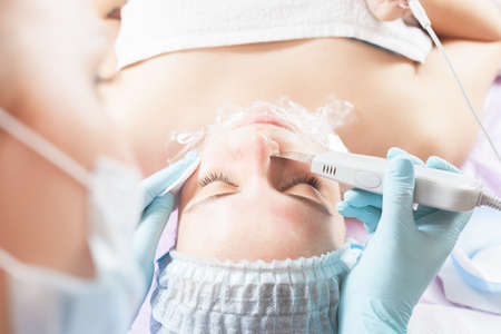 Woman in spa salon receive skin treatment. Creating occlusion for better atomization of the upper layer of the skin. Loosening of the skin. Face wrappingの写真素材