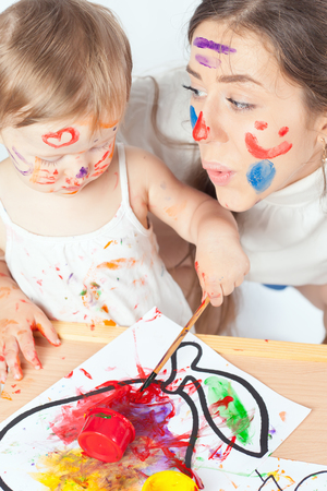 Mom and baby draws with colored inks paint. Games with child affect early development. Important to spend enough time with your kids.の写真素材