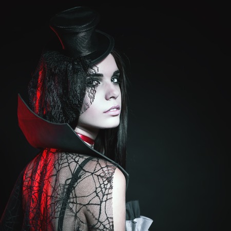 Portrait of sexy woman with gothic makeup smokey eyes. Vampire, evil. Goth. Horror. Secret. Fashion. Venetian carnival. Hot babe. Halloween party masqueradeの写真素材