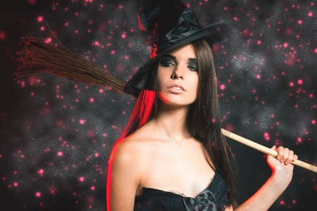 Halloween party. Beautiful woman like witch holding broom. Fashion. Halloween costumes. Role. Witch carnival costume. Role-playing games. Sexy girls. Night clubの写真素材