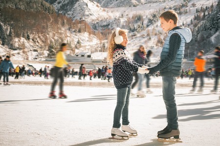Happy children ice skating at ice rink outdoor, figure skating, at winter day, sport and healthy lifestyle, ice skating at Holland. Funny kids, boy and girl, sister and brother. Familyの写真素材