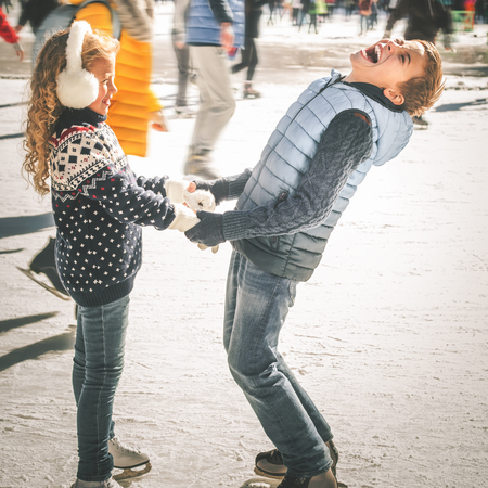 Happy children ice skating at ice rink outdoor, figure skating, at winter day, sport and healthy lifestyle, ice skating at Holland. Funny kids, boy and girl, sister and brother. Familyの写真素材