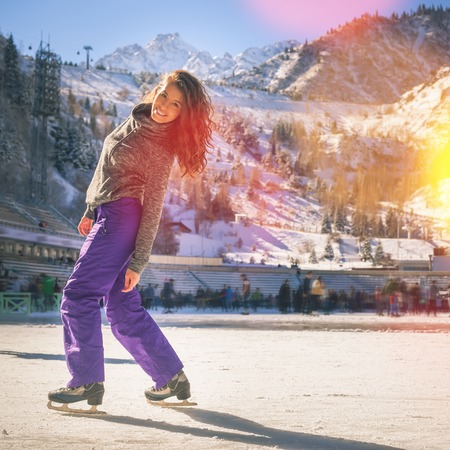 Latin girl ice skating outdoor at ice rink. Healthy lifestyle and winter sport concept at sports...