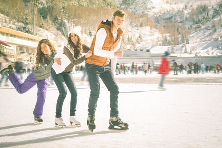 Funny teenagers girls and boy skating outdoor, ice rinkの写真素材