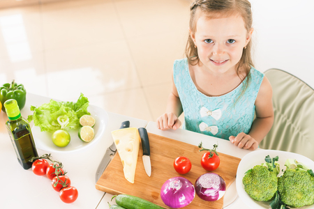Cute little girl making salad. Child cooking. Healthy foodの写真素材