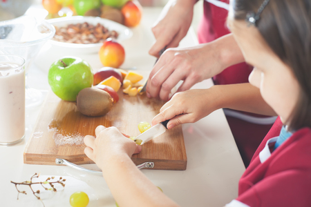 Cute little girl cooking with her mother, healthy foodの写真素材