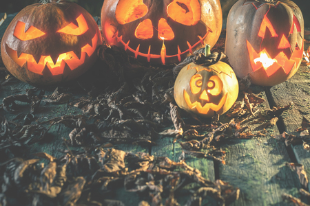 Halloween pumpkins at wood background. Carved scary faces of pumpkin.の写真素材