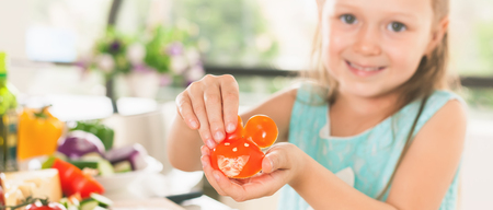 Cute little girl making salad. Child cooking. Healthy foodの写真素材