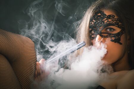 Young, beautiful girl smoke a hookah at club